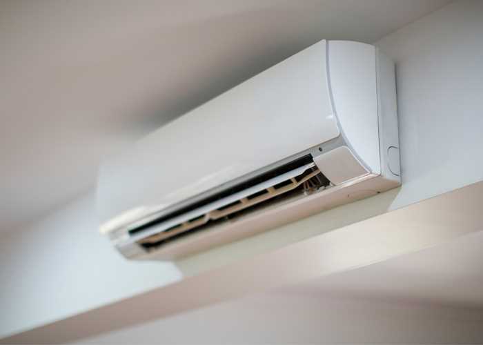 Wall-mounted split unit air conditioner being prepared for removal and relocation